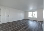 Thumbnail 34 of 34 - A room with a white door and a window with a view of trees outside.
