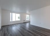 Thumbnail 32 of 34 - A room with wooden flooring and two windows.
