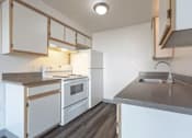 Thumbnail 24 of 34 - A kitchen with white appliances and wooden cabinets.