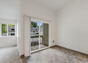 Thumbnail 13 of 36 - A room with a sliding glass door leading to a balcony.