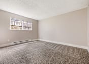 Thumbnail 19 of 31 - A room with a carpeted floor and a window.