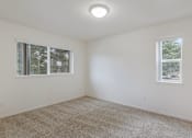Thumbnail 14 of 36 - A room with carpeted floor and two windows.