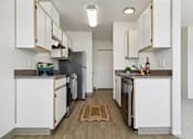 Thumbnail 48 of 74 - A kitchen with white cabinets and a wooden floor.