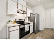 Thumbnail 14 of 74 - A modern kitchen with a stainless steel refrigerator and oven.