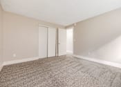 Thumbnail 20 of 31 - A room with carpeted floor and two doors.