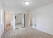 Thumbnail 15 of 36 - A spacious room with a carpeted floor and a mirror on the wall.