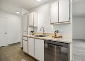 Thumbnail 15 of 74 - A kitchen with a stainless steel dishwasher and wooden cabinets.