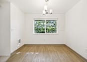 Thumbnail 22 of 37 - A room with a window and a wooden floor.