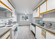 Thumbnail 14 of 37 - A kitchen with white appliances and wooden cabinets.