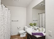Thumbnail 24 of 44 - A white toilet sits next to a sink in a bathroom.