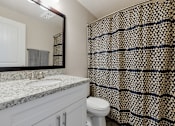 Thumbnail 17 of 31 - A bathroom with a marble countertop and a toilet.