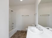 Thumbnail 18 of 36 - A white bathroom with a toilet, sink, and a shower.