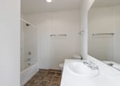 Thumbnail 16 of 36 - A white bathroom with a toilet, sink, and shower.