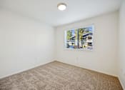 Thumbnail 8 of 37 - A room with a carpeted floor and a window with blinds.