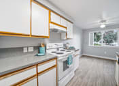 Thumbnail 15 of 37 - A kitchen with white cabinets and a white stove top oven.