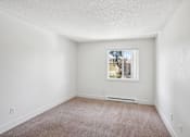 Thumbnail 25 of 44 - A room with a window and a carpeted floor.