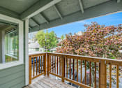 Thumbnail 51 of 66 - A wooden balcony with a trees in the distance
