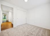 Thumbnail 9 of 37 - A room with a carpeted floor and a white door.
