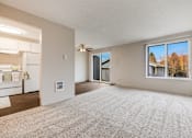 Thumbnail 22 of 31 - A spacious living room with a carpeted floor and a large window.