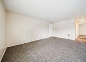 Thumbnail 19 of 35 - A spacious room with a grey carpet and white walls.