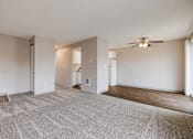 Thumbnail 23 of 31 - A spacious room with a carpeted floor and a ceiling fan.