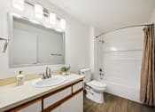 Thumbnail 10 of 37 - A bathroom with a white toilet, sink, and a mirror above the sink.