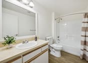 Thumbnail 24 of 37 - A bathroom with a white toilet, sink, and shower.
