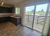Thumbnail 3 of 17 - A kitchen with black cabinets and a tiled floor.