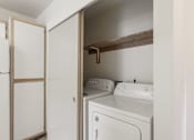 Thumbnail 20 of 36 - A white washer and dryer in a small laundry room.