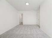Thumbnail 21 of 74 - A large, empty room with a carpeted floor and white walls.