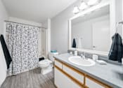 Thumbnail 16 of 37 - A bathroom with a toilet, sink, and shower curtain.