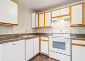 Thumbnail 22 of 35 - A kitchen with white appliances and wooden cabinets.
