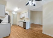 Thumbnail 56 of 66 - A kitchen with white cabinets and a wooden floor.