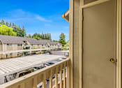 Thumbnail 24 of 36 - A view from a balcony of a building with a car parked in the driveway.