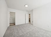 Thumbnail 22 of 74 - A large, empty room with a carpeted floor and a single light fixture on the ceiling.