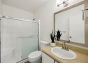 Thumbnail 23 of 74 - A bathroom with a toilet, sink, and mirror.