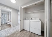 Thumbnail 17 of 37 - A white laundry room with a washer and dryer.