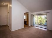 Thumbnail 29 of 40 - A room with a sliding glass door leading to a balcony.