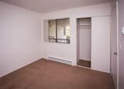 Thumbnail 35 of 40 - A room with a brown carpet and a window with bars.