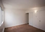 Thumbnail 39 of 40 - A room with white walls and a brown floor.