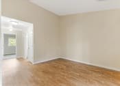 Thumbnail 59 of 66 - Empty room with wooden flooring and white walls.