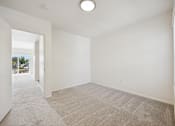 Thumbnail 59 of 74 - A large, empty room with a carpeted floor and white walls.