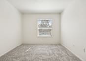 Thumbnail 25 of 74 - A room with a carpeted floor and a window with blinds.