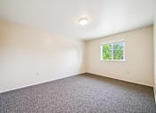 Thumbnail 26 of 35 - A room with a window and carpeted floor.