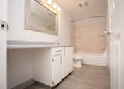 Thumbnail 49 of 64 - A white bathroom with a toilet, sink, and bathtub.
