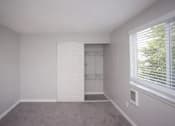 Thumbnail 48 of 64 - A room with a white door and a window with blinds.