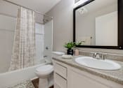 Thumbnail 28 of 31 - A white bathroom with a sink, toilet, and shower.