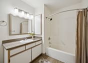 Thumbnail 61 of 74 - A bathroom with a sink, mirror, and bathtub.