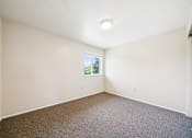 Thumbnail 29 of 35 - A room with a window and carpeted floor.