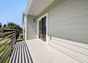 Thumbnail 64 of 74 - A house with a grey siding and a glass door.